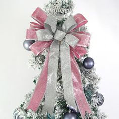 a white christmas tree with pink and silver ornaments