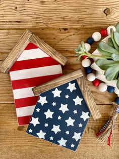 three patriotic coasters sitting on top of a wooden table next to some plants and decorations