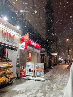 a person walking down the street in front of a wine store on a snowy day