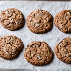 six cookies are arranged on a piece of parchment paper