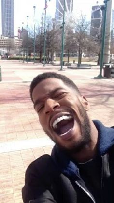 a man is laughing while taking a selfie