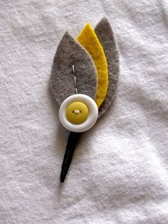 a close up of a flower on a white cloth with a needle in the middle