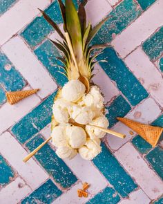 a pineapple and ice cream cone on a blue and white tile floor with cones