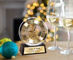 a glass of wine and a clock on a table next to a christmas ornament