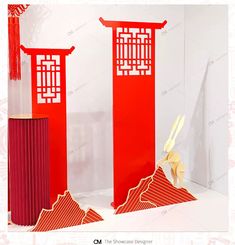 two tall red pillars sitting next to each other on top of a white tablecloth