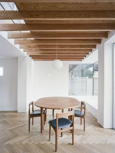 a dining room table and chairs in an empty room with wooden beams on the ceiling