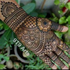 the hand is decorated with henna designs and has intricate patterns on its palm, which can be seen in this photo