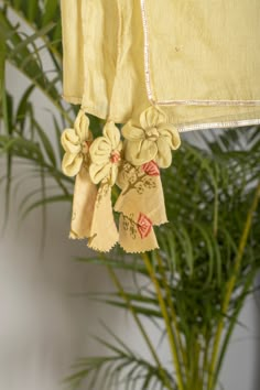 some yellow flowers are hanging from the side of a window sill next to a potted plant