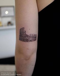 a woman's arm with a small tattoo of the colossion in rome