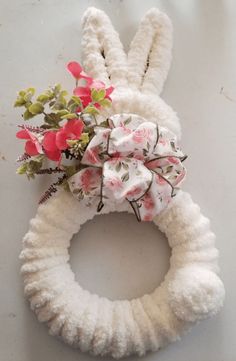 a white bunny shaped wreath with flowers on it