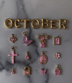 the word october spelled out in gold letters with pink and white cross pendants on them