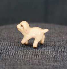 a small white dog figurine sitting on top of a couch