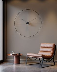 a chair and table in front of a large clock