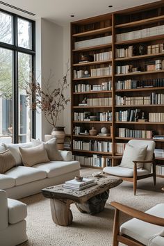 a living room filled with lots of bookshelves next to a couch and coffee table