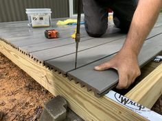 a man working on a deck with tools