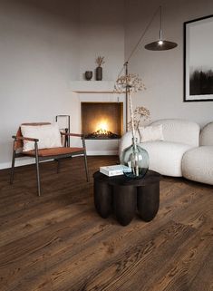 a living room filled with furniture and a fire place next to a white couch on top of a hard wood floor