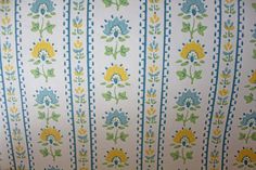 an upholstered wallpaper with flowers and leaves on white, blue, yellow and green stripes