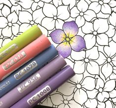 several crayons sitting on top of each other in front of a flower design