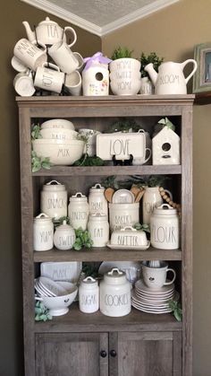 a wooden shelf filled with white dishes and cups on top of it's sides