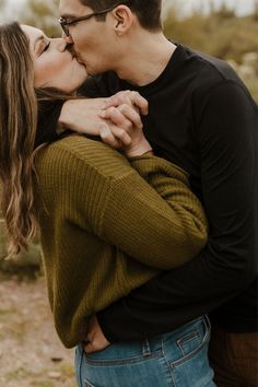 a man and woman kissing each other in the desert