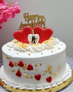 a white cake with red hearts on top