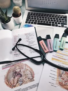 an open book sitting on top of a desk next to a laptop computer and medical supplies