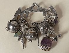 Antique  Ragastens Prata 95 Penca de Balangandan  sterling silver amulet brooch. 10 charms - amulets.  wt.: 43.22 grams  Excellent condition  marked: Prata 95 and Ragastens ( was cut, but you can see some letters ) PHOTO # 4.  all sizes approximately:  size - 2.75" x 2.75"  2 amethyst stones, 1 green stone, sterling silver ( acid tested )  Shipping with insurance, signature confirmation required. 04/26/24 SS156 Amulet Pendant Jewelry Souvenir, Souvenir Amulet Pendant Jewelry, Souvenir Pendant Amulet Jewelry, Antique Sterling Silver Charms In Silver, Antique Silver Sterling Silver Charms, Traditional Handmade Sterling Silver Brooches, Sterling Silver Brooch In Silver, Sterling Silver Brooch Jewelry In Silver, Silver Sterling Silver Pendant Brooches