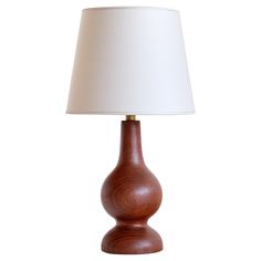 a wooden table lamp with a white shade