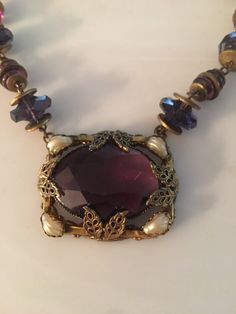 "Beautiful Art Nouveau amethyst glass and shell Pearl brass choker. Circa 1905 Necklace measure 14\" with a 1.5\" pendant. Probably Czech. Thank you !" Purple Art Deco Necklace For Gift, Antique Handmade Amethyst Necklace, Vintage Purple Pendant Necklace, Handmade Antique Amethyst Necklace, Handmade Vintage Amethyst Jewelry, Purple Amethyst Necklace For Collectors, Antique Purple Pendant Necklace, Vintage Amethyst Pendant Necklace, Antique Glass Necklaces For Collectors