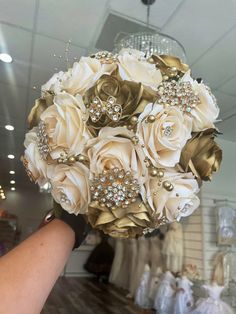 a bridal bouquet is being held up by someone's hand in a store