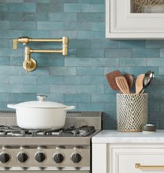 a stove top oven sitting in a kitchen next to a wall mounted faucet