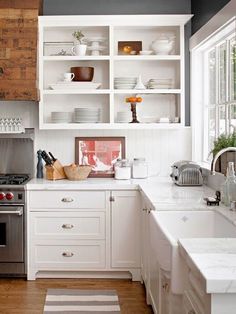 the kitchen is clean and ready to be used for cooking or baking, with white cabinetry and stainless steel appliances