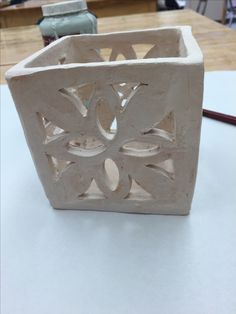 a white vase sitting on top of a table