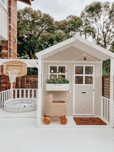 a small white shed with a basket in the door and a basketball hoop on top