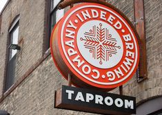 a red and white sign that reads taproom on the side of a brick building