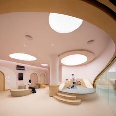 the interior of a modern building with circular lights and curved staircases on both sides