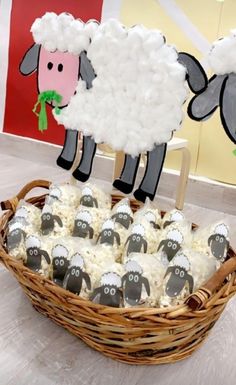 a basket filled with cupcakes and sheep cut out of the top of them