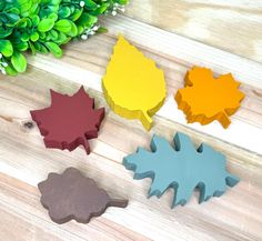 four leaf shaped cookie cutters sitting on top of a wooden table