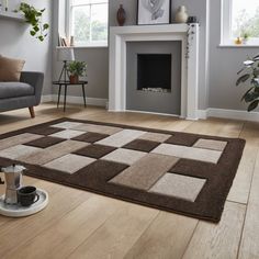 a living room with a couch, chair and rug in front of a fire place