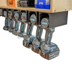 several electric drillers are lined up on a shelf