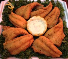 a white plate topped with fried fish covered in sauce