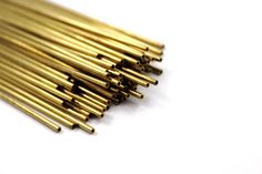 several gold colored metal rods on a white surface