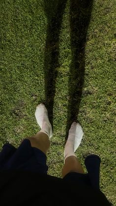 a person standing in the grass with their legs crossed