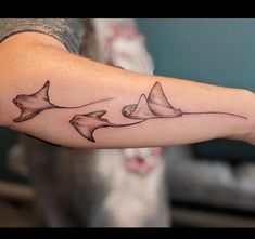 a man's arm with three sharks on it