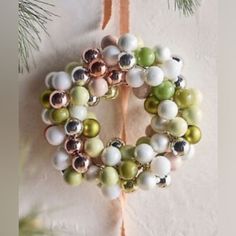 a christmas ornament hanging from a tree branch with ornaments on it's side