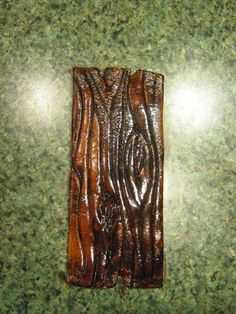 a piece of wood sitting on top of a green counter next to a tile floor