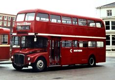 two red double decker buses parked next to each other