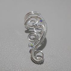 New modern handmade adjustable swirly silver-plated ear cuff. This unique ear cuff is easily adjustable with 2 lovely swarovski crystals added to the elegant curls and swirls. It looks so pretty on the ear. No need for piercing with these cuffs as they just slip on to any ear. This listing is for one ear cuff. Please choose left or right or both in the menu when ordering. See our Ear Cuffs here: https://www.etsy.com/uk/shop/ElectriccDreams?ref=seller-platform-mcnav&section_id=15051355 Have a loo Elegant Adjustable Spiral Wrap Earrings, Elegant Adjustable Silver Wrap Earrings, Silver Adjustable Spiral Wrap Earrings, Elegant Silver Spiral Ear Cuff, Unique Silver Spiral Wrap Earrings, Elegant Spiral Ear Cuff, Elegant Silver Crystal Ear Cuff, Adjustable Spiral Ear Cuff, Elegant Adjustable Wire Wrapped Ear Climbers