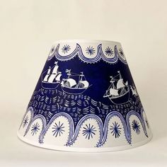 a blue and white lamp shade with ships on it