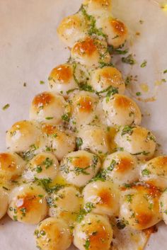 a pile of food sitting on top of a white paper covered in cheese and herbs